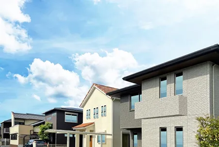 青空の下に並ぶ現代的な住宅街の風景。新築またはリフォーム済みの住宅が立ち並ぶ。