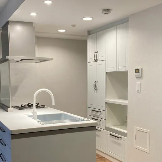 白を基調としたシンプルで清潔感のあるキッチン。収納スペースが充実した設計。