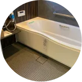 広々とした浴室。白い浴槽とダークブラウンの壁が特徴的。