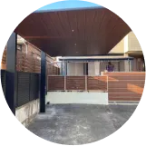 モダンなデザインのカーポート。木目調の屋根と金属製の支柱が特徴的。