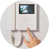 インターホンの画面を見ながらボタンを押す手