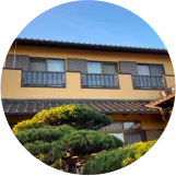 二階建ての和風住宅の外観。整えられた庭木が特徴的。