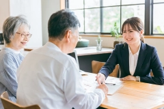 年配夫婦と女性スタッフが契約の相談をしている様子