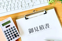 御見積書と電卓、キーボードが置かれたデスク