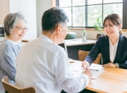 テーブルで話し合うシニア夫婦と女性スタッフ