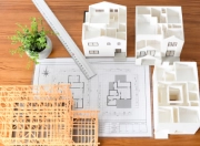 木製の模型と住宅設計図が置かれたテーブル
