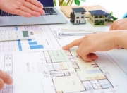間取り図を指差して打ち合わせする人々の手元